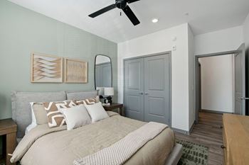 A bedroom with a large bed and a ceiling fan